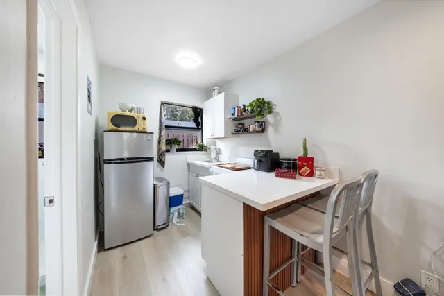 a kitchen with a refrigerator a stove a microwave a dining table and chairs