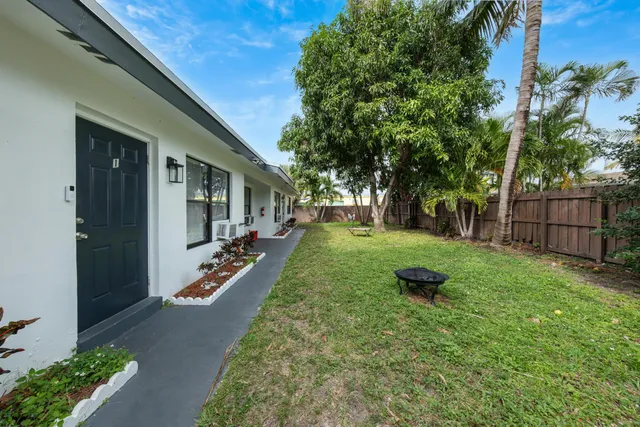 a view of a backyard with table and chairs and wooden fence