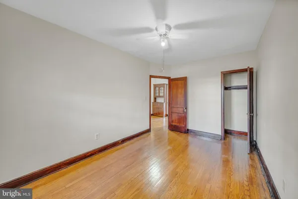 a spacious bedroom with a bed and wooden floor