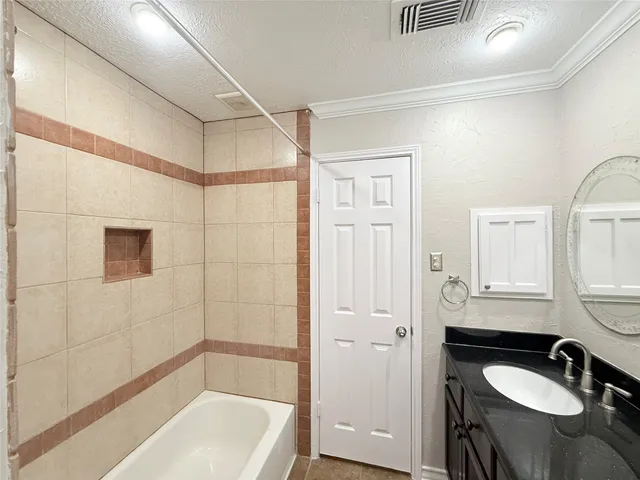 a bathroom with a granite countertop sink a mirror and a bathtub