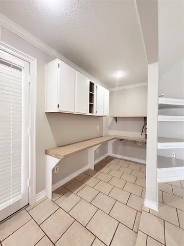 a kitchen with white cabinets and counter space