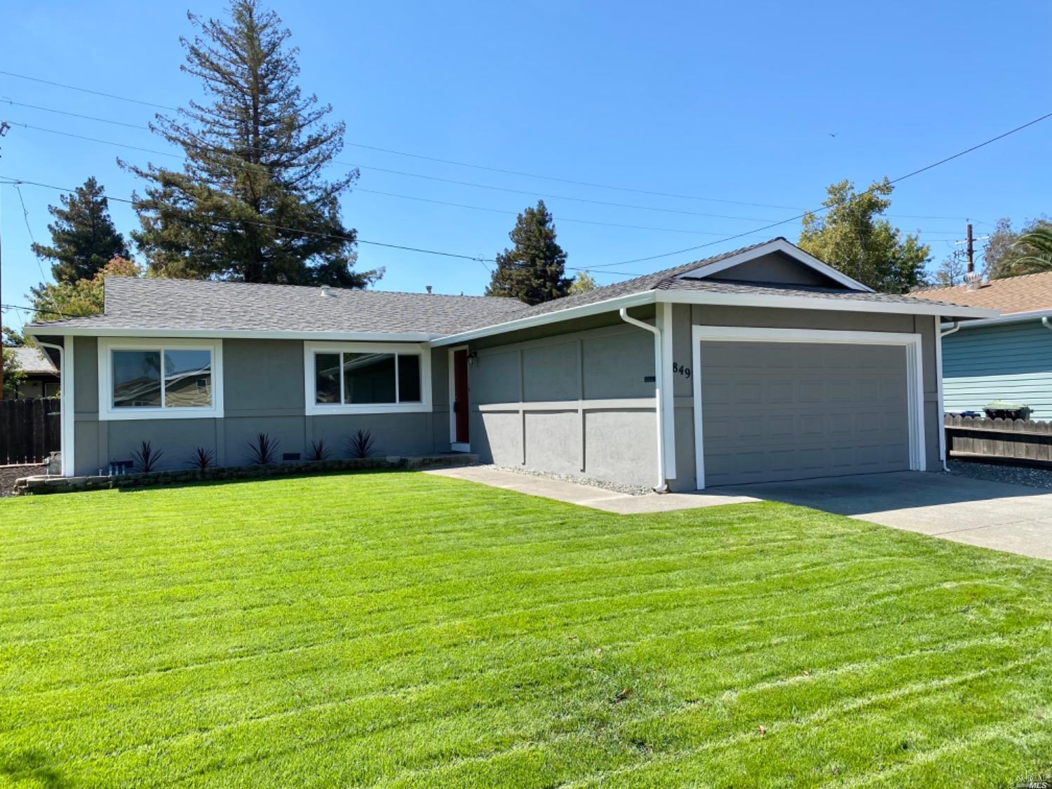 a front view of a house with yard and trees