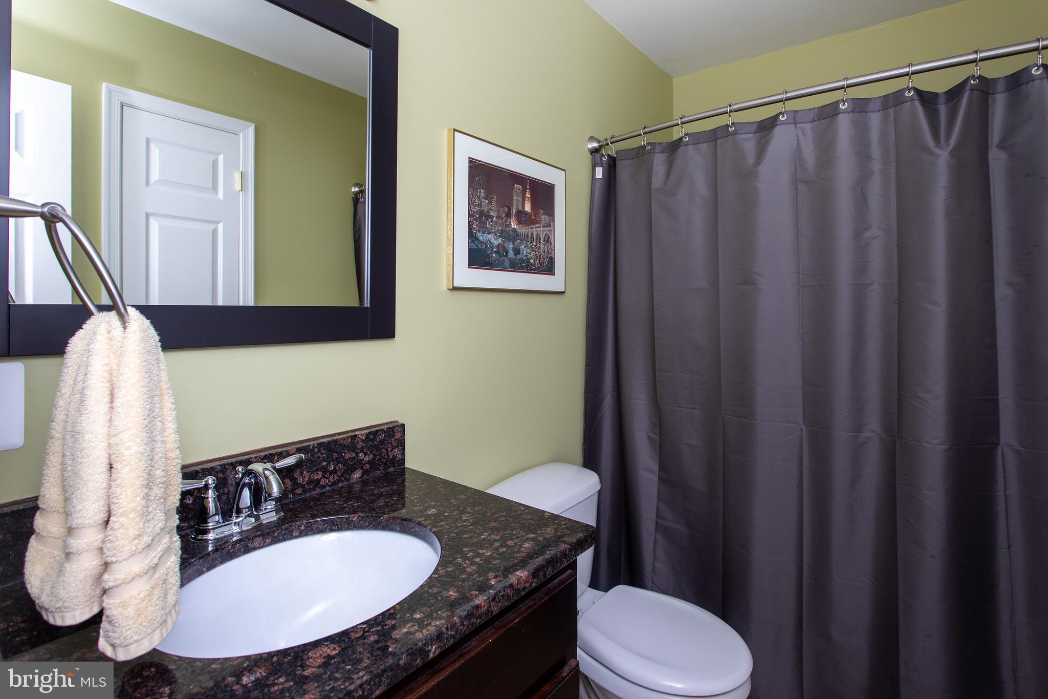 540 Thunderbird Drive Lusby, MD 20657 - Photo 26 of 66 a bathroom with a sink a toilet a mirror and shower curtain