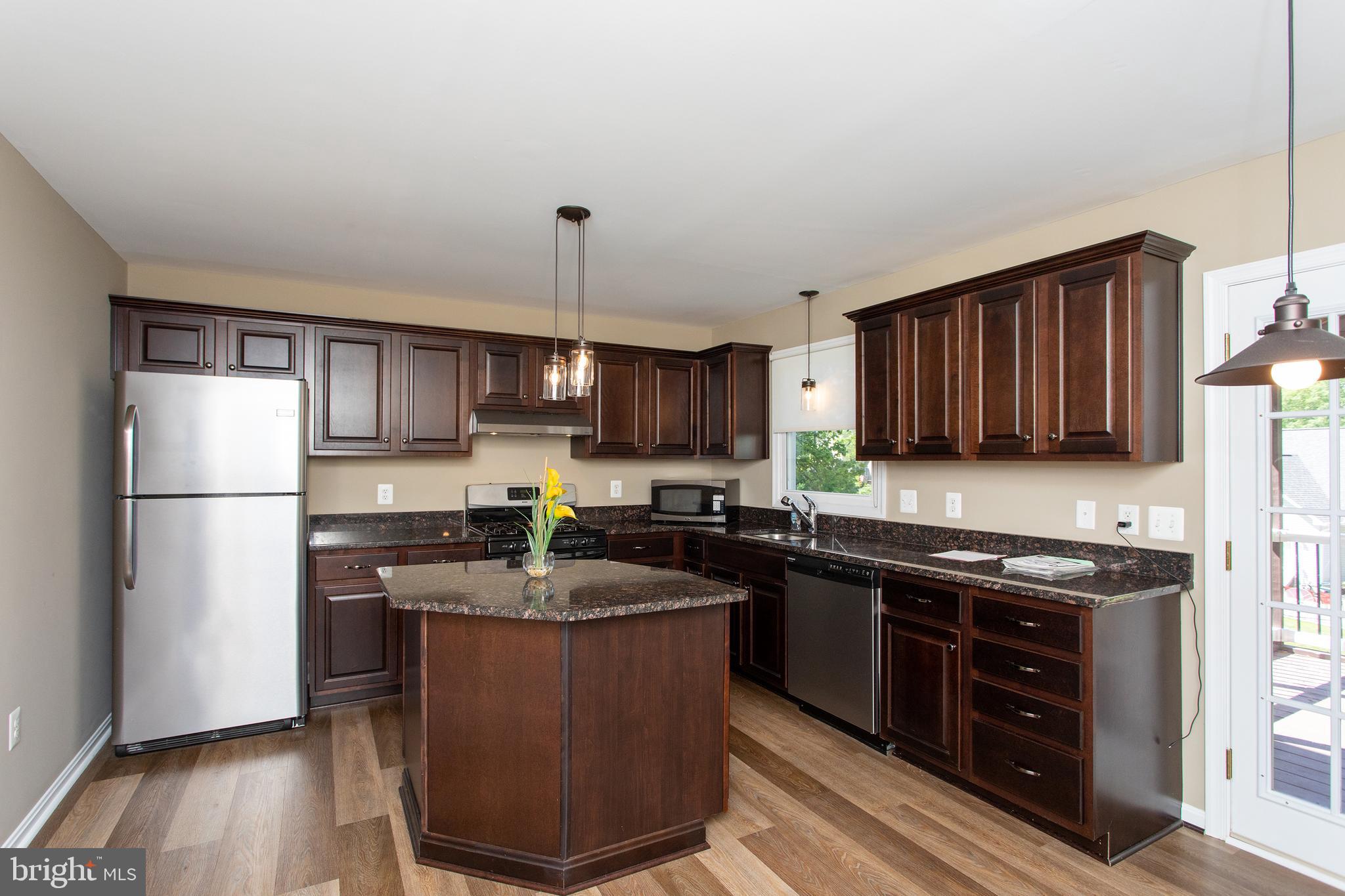 540 Thunderbird Drive Lusby, MD 20657 - Photo 31 of 66 a kitchen with stainless steel appliances granite countertop a stove a sink dishwasher a refrigerator and a microwave oven on the wooden floor
