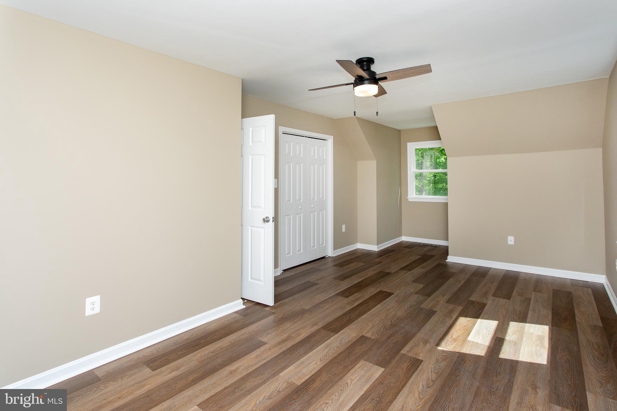 540 Thunderbird Drive Lusby, MD 20657 - Photo 7 of 66 an empty room with wooden floor ceiling fan and windows
