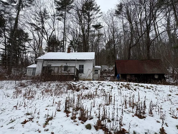 a front view of a house with a yard covered with snow