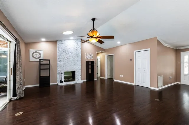 a view of a livingroom with wooden floor and a ceiling fan