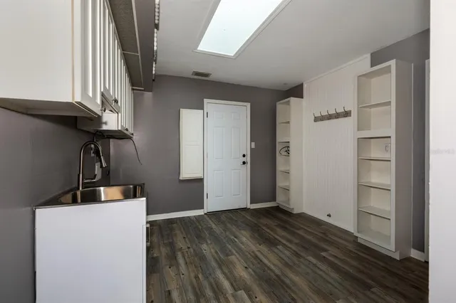 a view of empty room with wooden floor and window