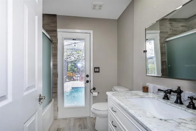 a bathroom with a granite countertop sink toilet and shower