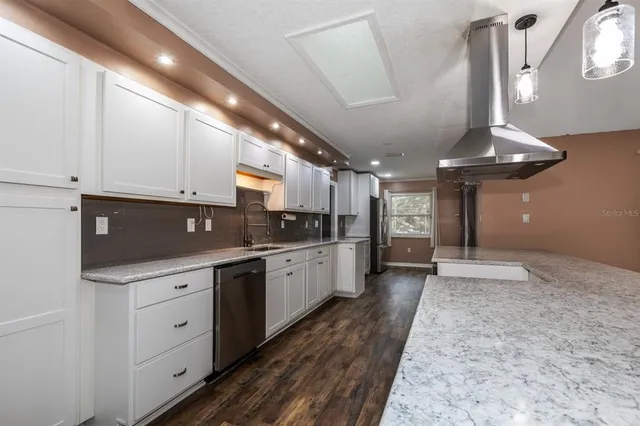 a large kitchen with kitchen island a sink stainless steel appliances and cabinets