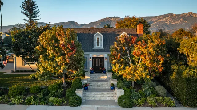 a front view of a house with a yard and tree s
