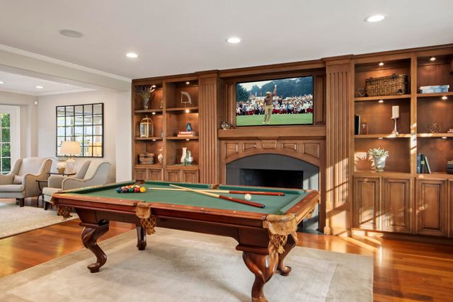 a living room with furniture pool table and a fireplace