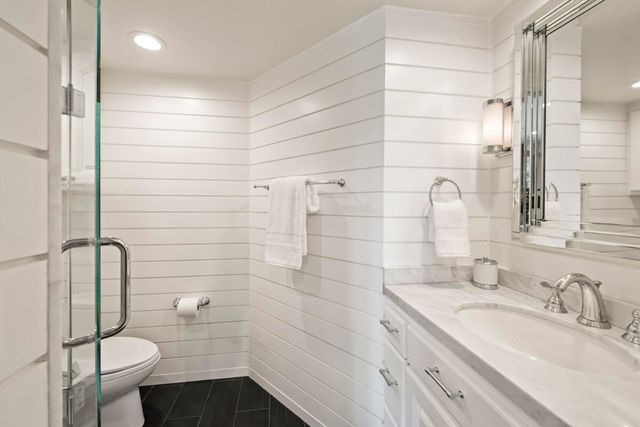 a bathroom with a granite countertop sink toilet and shower