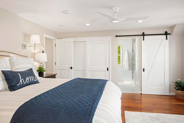 a bedroom with a large bed and wooden floor