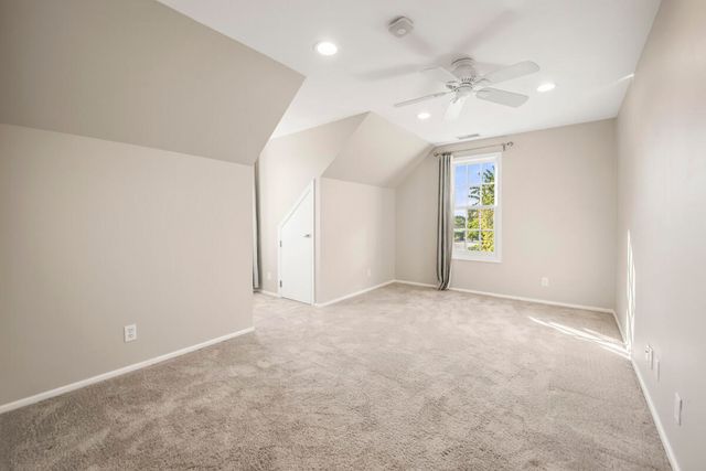 an empty room with windows and chandelier fan
