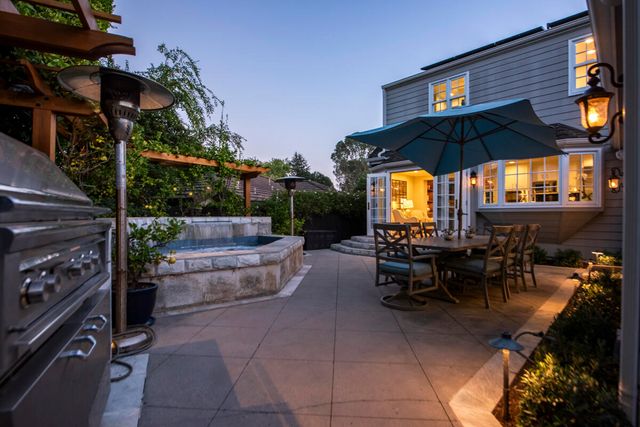 a view of a patio with table and chairs under an umbrella with a patio