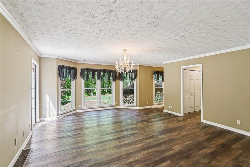 13597 Woolsey Road Hampton, GA 30228 - Photo 13 of 87 a view of an empty room with wooden floor and a window