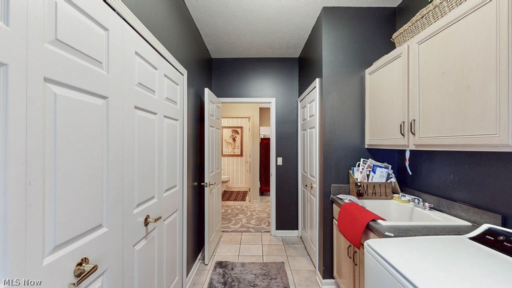 36845 Aberdeen Lane Solon, OH 44139 - Photo 10 of 24 Laundry room featuring washer / dryer, cabinet space, and light tile patterned floors