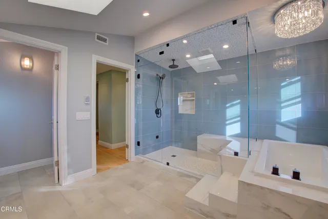 a bathroom with a bath tub sink shower and mirror