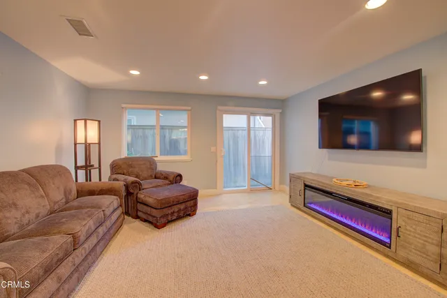 a living room with furniture kitchen view and a large window