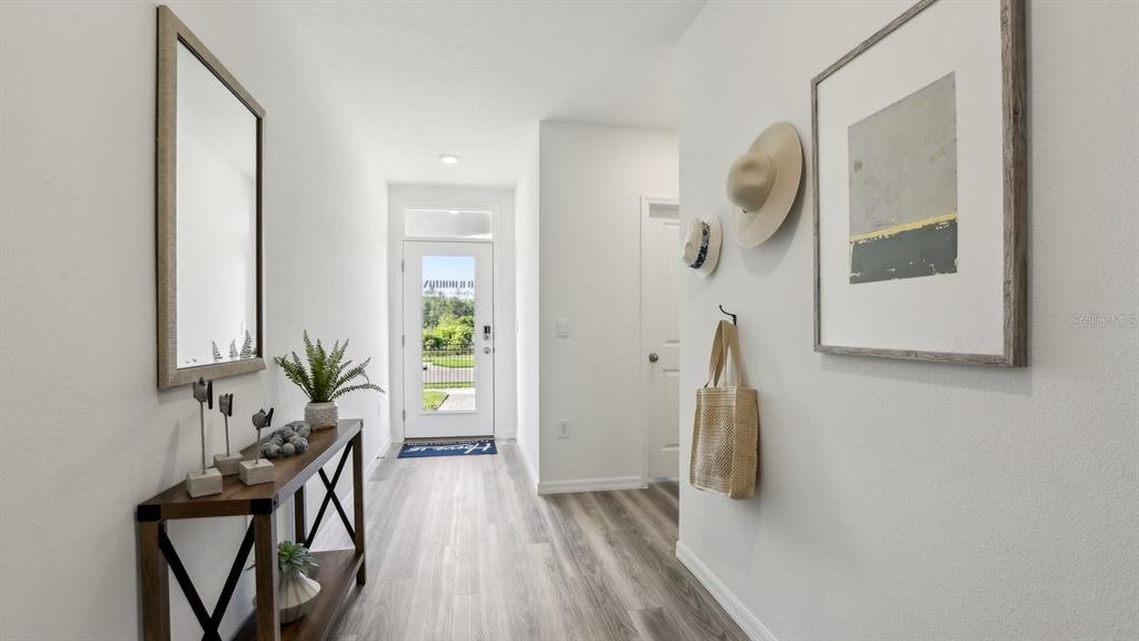 1046 Spotted Egret Loop Ruskin, FL 33570 - Photo 2 of 37 a view of a hallway with wooden floor and a bathroom