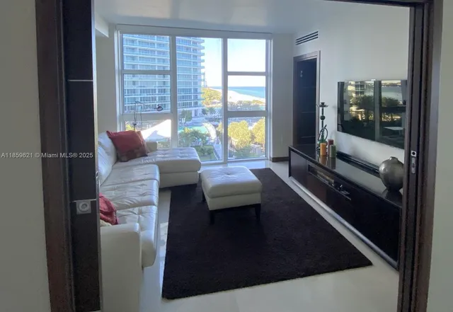 a living room with furniture and a floor to ceiling window