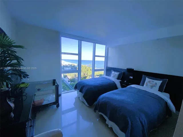 a bedroom with two beds and a potted plant