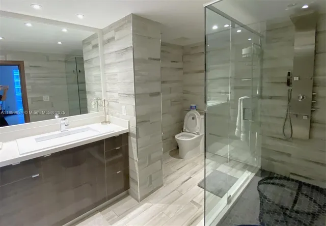 a bathroom with a double vanity sink toilet and shower