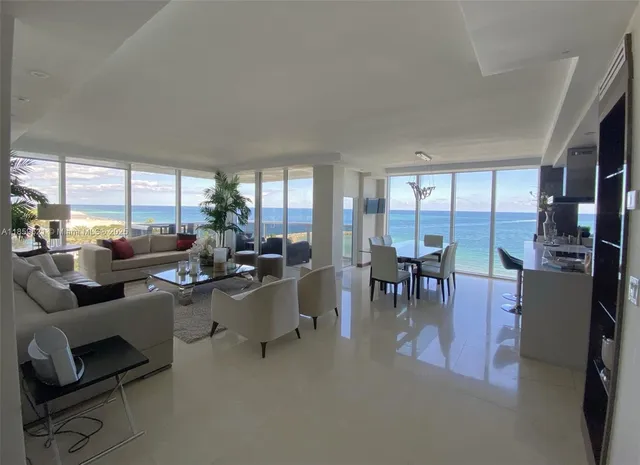 a room with lots of tables a large window and chairs