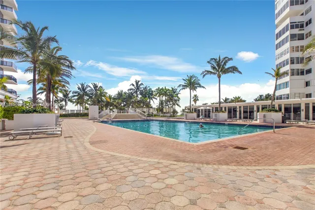 a view of swimming pool with outdoor seating and plants