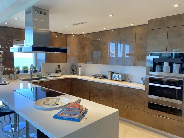 a kitchen with stainless steel appliances kitchen island granite countertop a sink dishwasher stove and refrigerator with wooden floor