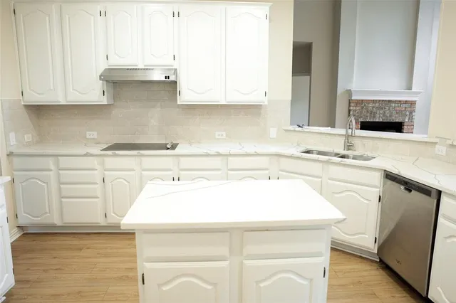a kitchen with a sink cabinets and wooden floor