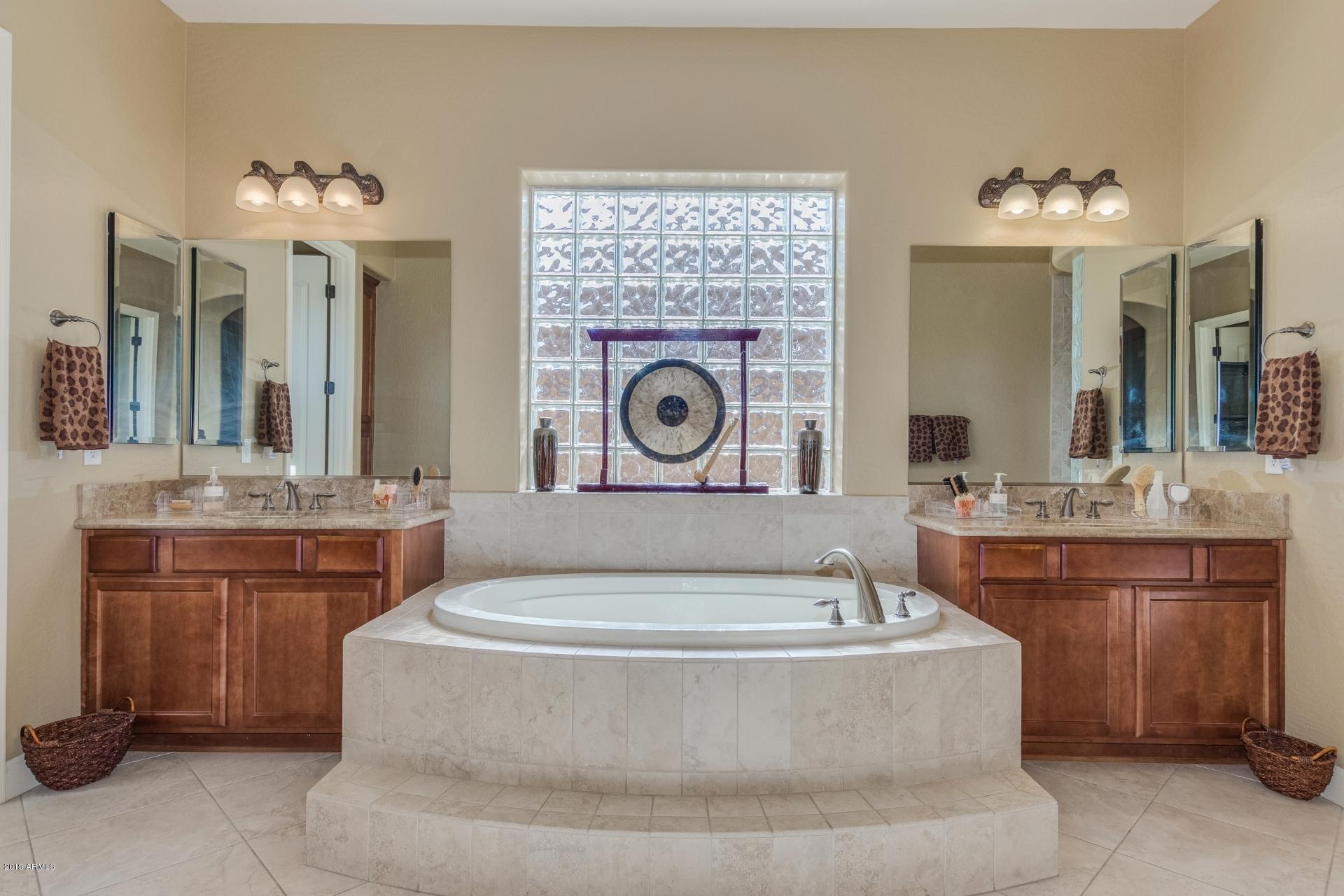 18168 West Narramore Road Goodyear, AZ 85338 - Photo 20 of 36 a spacious bathroom with a tub sink and mirror