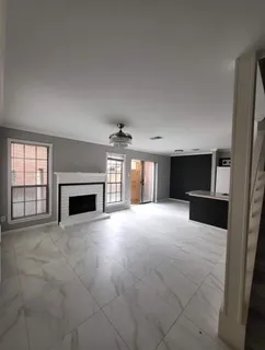 an empty room with windows and fireplace