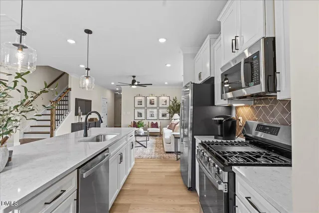 a large kitchen with stainless steel appliances granite countertop a lot of counter space a sink and a stove