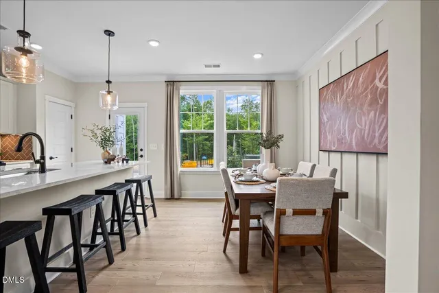 a dining room with furniture a chandelier and wooden floor