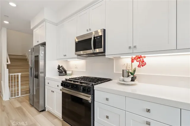 a kitchen with stainless steel appliances white cabinets and a stove a oven with white countertops