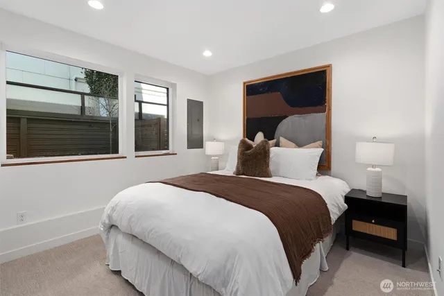 a bedroom with a bed and a large window