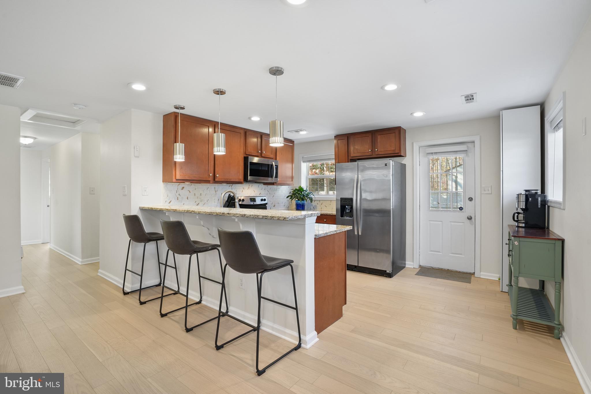 15709 Maple Drive Accokeek, MD 20607 - Photo 17 of 48 a kitchen with stainless steel appliances kitchen island granite countertop a refrigerator and a stove top oven