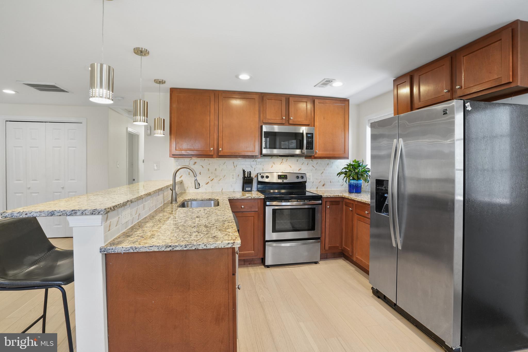 15709 Maple Drive Accokeek, MD 20607 - Photo 18 of 48 a kitchen with granite countertop a refrigerator and a sink