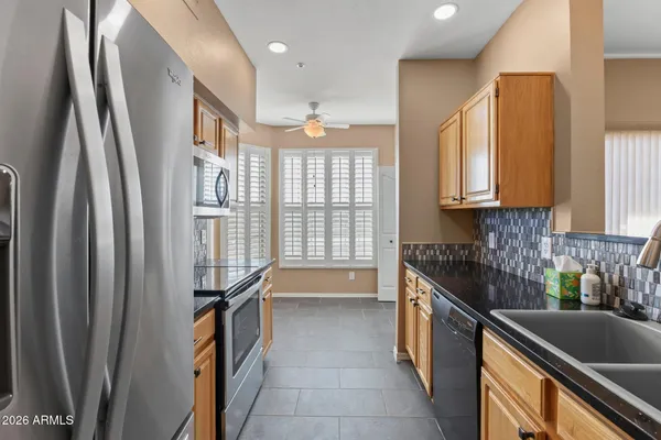 a kitchen with stainless steel appliances granite countertop a refrigerator and a sink