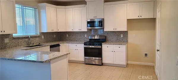 a kitchen with granite countertop white cabinets and white appliances