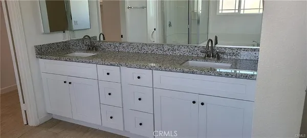 a bathroom with double sink and a mirror
