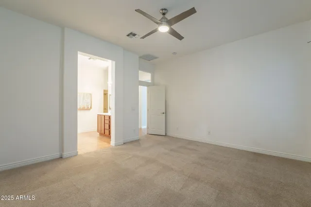 a kitchen with stainless steel appliances a white table chairs and a refrigerator