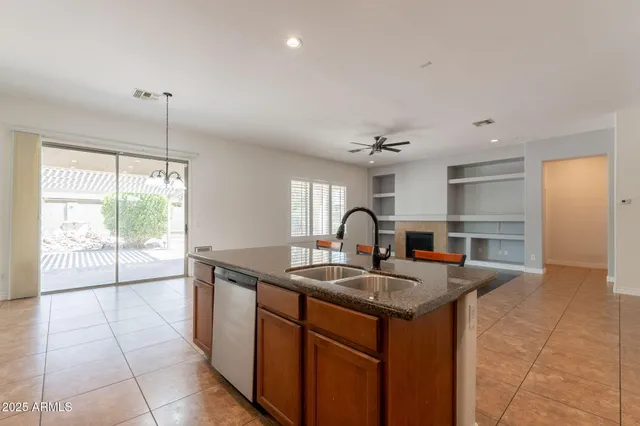a kitchen with stainless steel appliances a white table chairs and a refrigerator