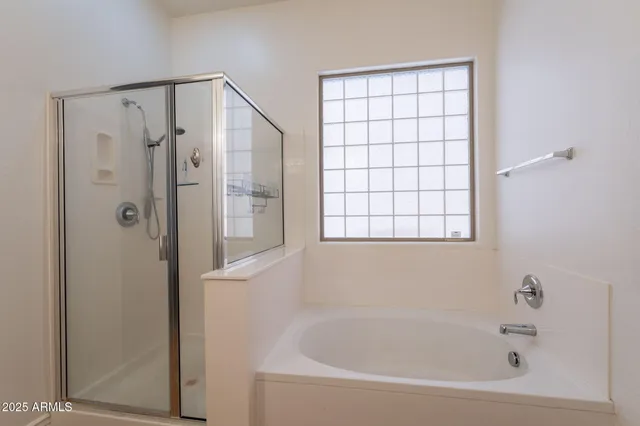 a bathroom with a tub shower vanity and a sink