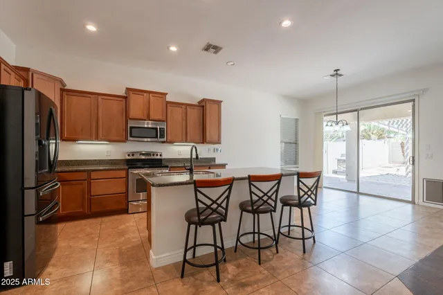 a kitchen with kitchen island granite countertop wooden cabinets and stainless steel appliances