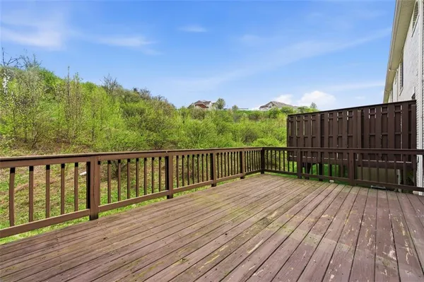 a view of balcony with wooden floor and fence