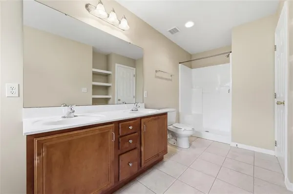 a bathroom with a granite countertop sink a toilet and a mirror