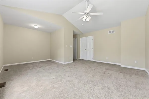 an empty room with a ceiling fan and a window